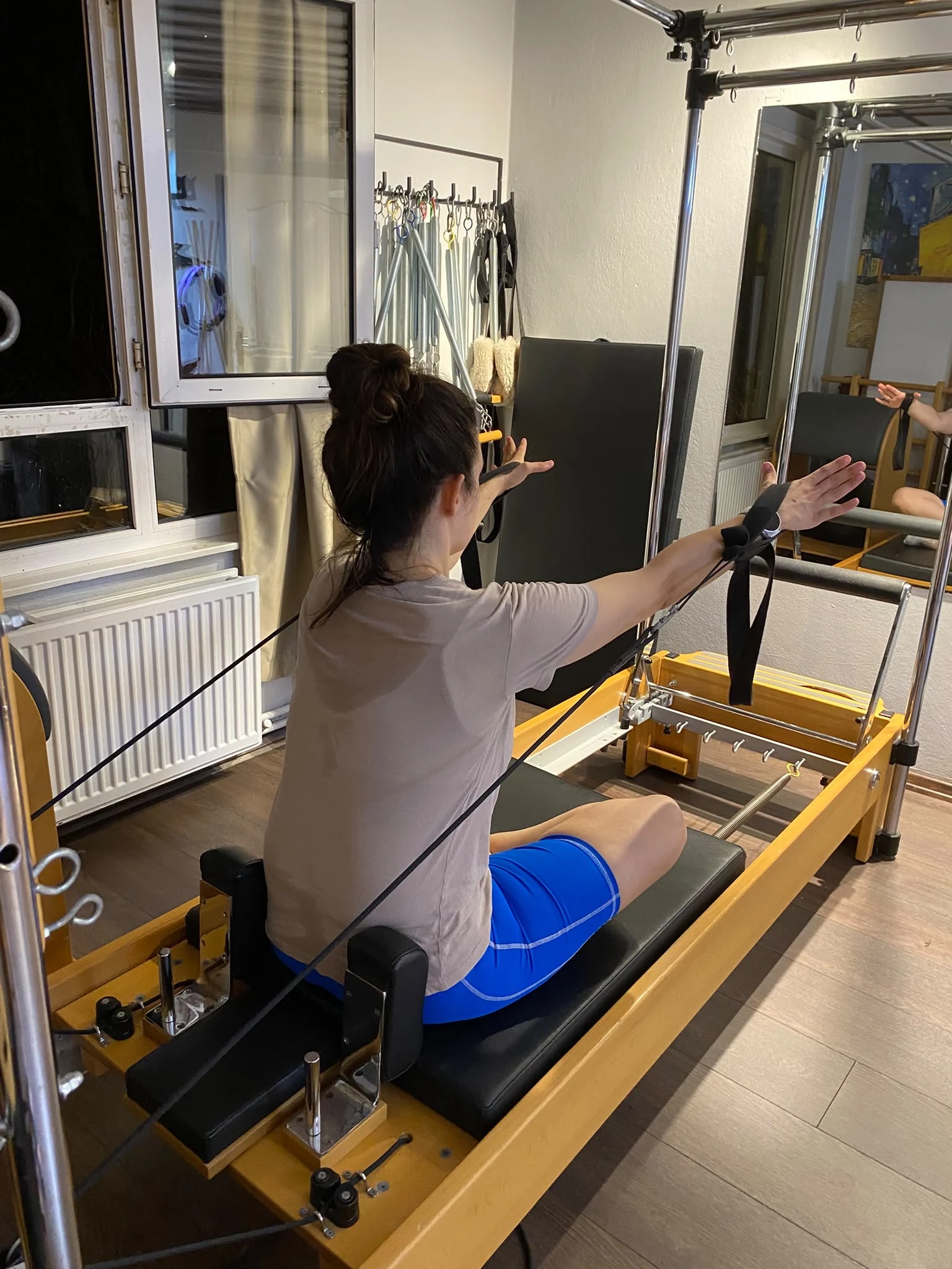 Üyenin reformer üzerinde kollar açık çalışması